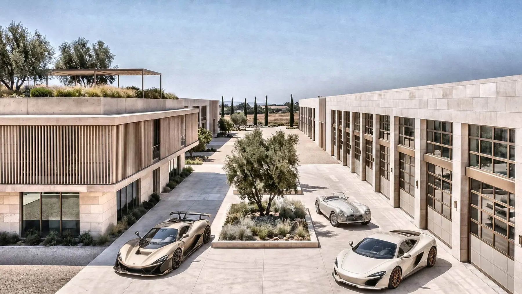 A motor court between pale stone suite buildings, planted with olive trees